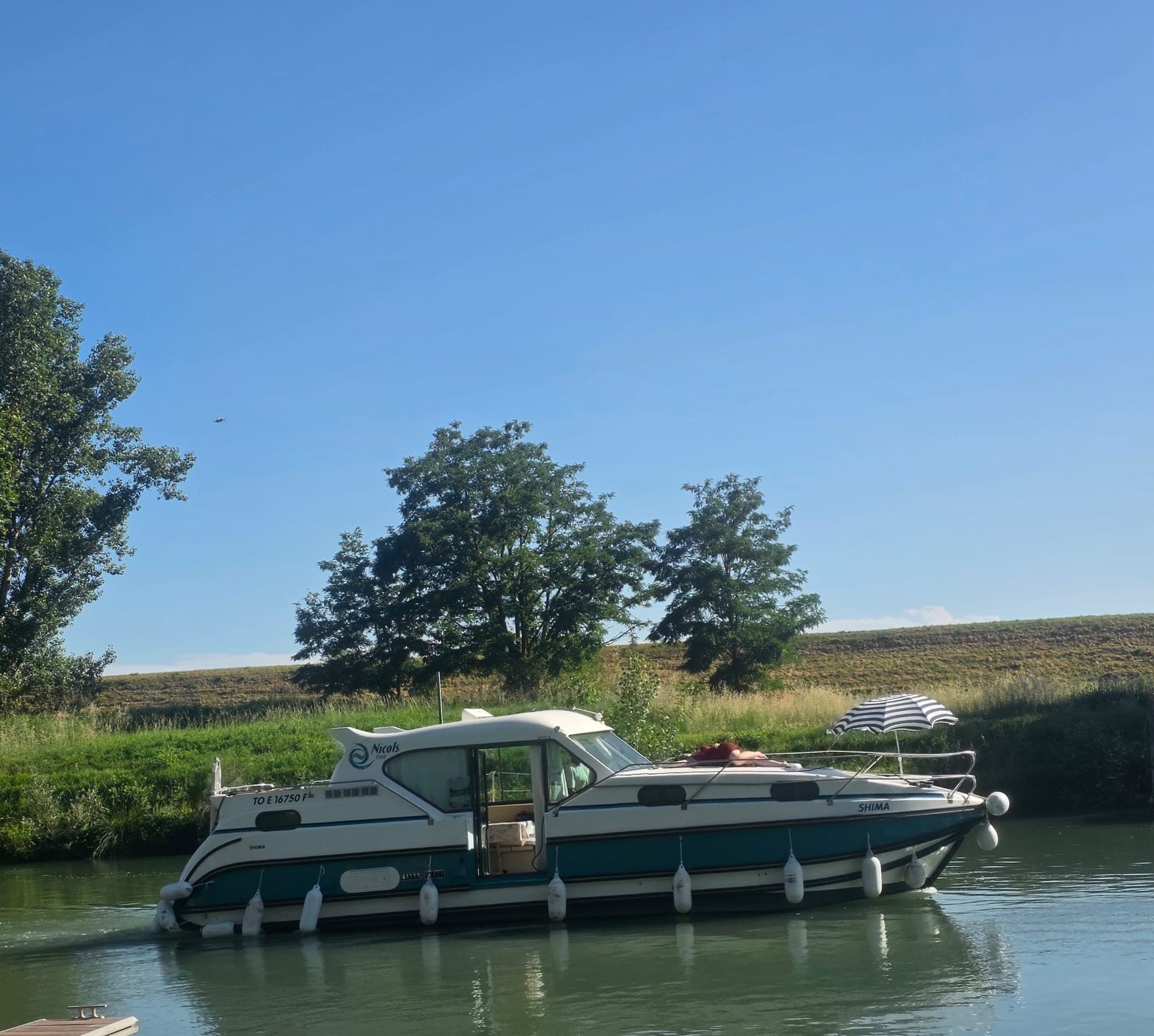 Petit bateau ponton privé avec un groupe à bord sur la rivière