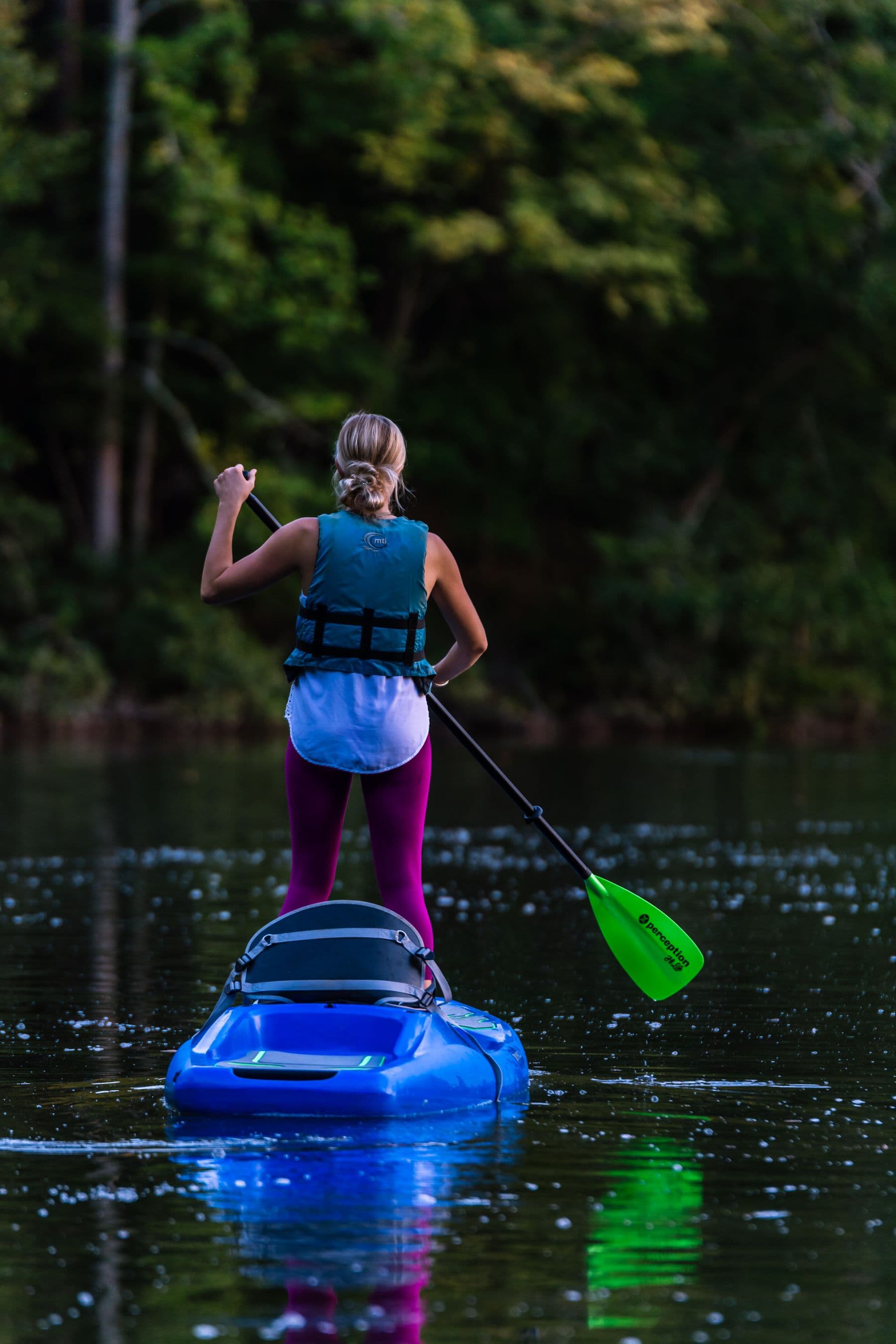 Paddle sur un plan d'eau calme bordé de forêt