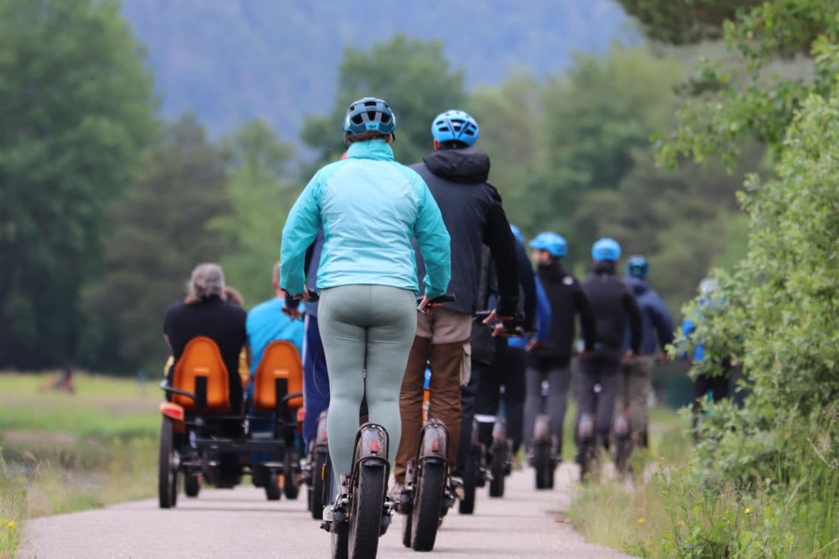 Groupe en trottinette tout-terrain casque sur un chemin nature